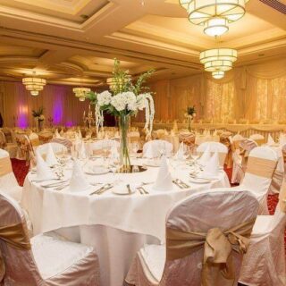 Elegant ballroom with round tables and white decor at Hamlet Court Hotel.