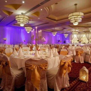 Elegant event space at Hamlet Court Hotel with illuminated chandeliers and gold accents.