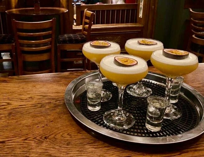 Cosy hotel bar with wooden decor, cocktails and warm lighting.