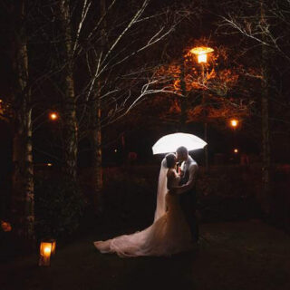 Romantic wedding scene under lantern-lit trees at Hamlet Court Hotel.