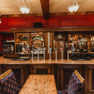 Cosy hotel bar with rustic wooden decor and inviting lighting.