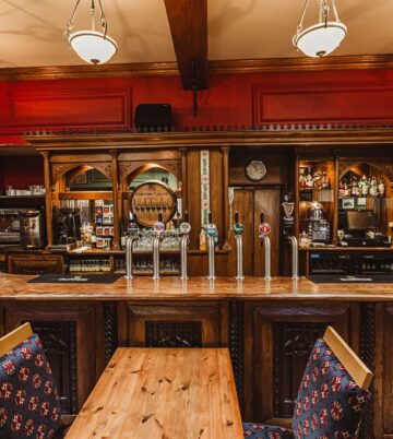 Cosy hotel bar with rustic wooden decor and inviting lighting.