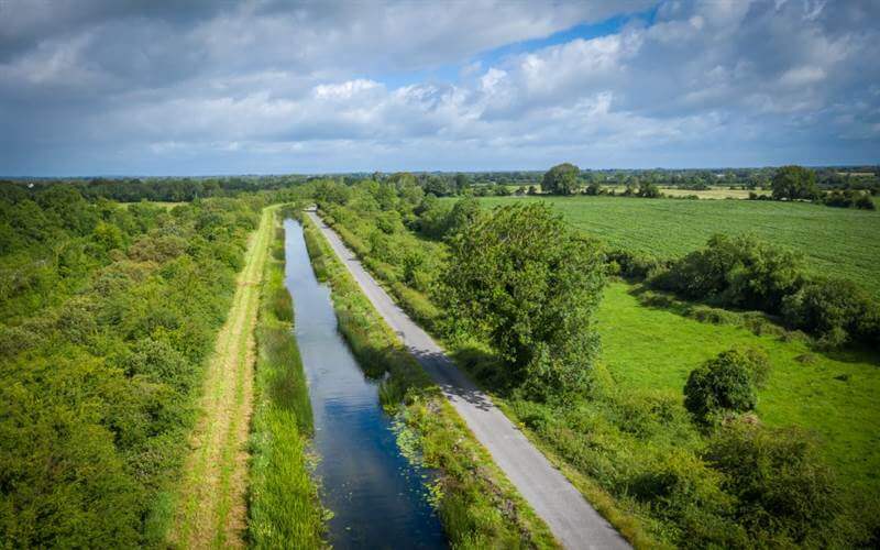 Scenic countryside view near Hamlet Court Hotel with lush greenery and serene waterway.
