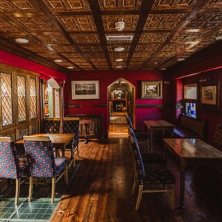 Cosy hotel lounge with elegant woodwork, plush seating, and warm lighting.