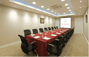 Modern conference room with red-covered tables at Hamlet Court Hotel.