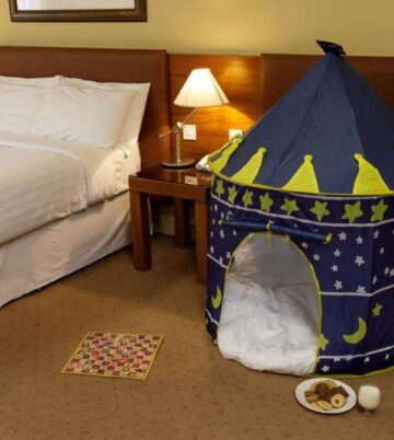 Cosy hotel room with double bed and children's play tent, creating a family-friendly atmosphere.