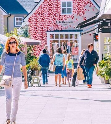 Charming courtyard at Hamlet Court Hotel, surrounded by vibrant flowers and quaint shops.