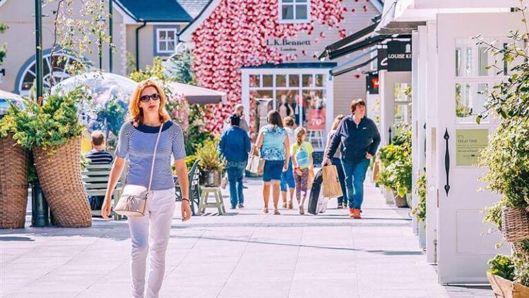 Charming courtyard at Hamlet Court Hotel, surrounded by vibrant flowers and quaint shops.