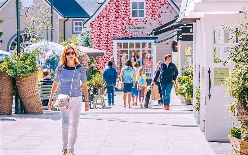 Charming courtyard at Hamlet Court Hotel, surrounded by vibrant flowers and quaint shops.