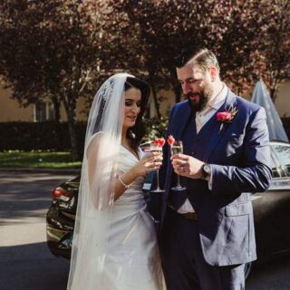 Bride and groom celebrate with champagne at Hamlet Court Hotel garden.