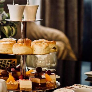 Elegant high tea setup with scones and cakes at Hamlet Court Hotel.
