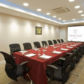 Spacious, elegant conference room at Hamlet Court Hotel with red tablecloth and modern seating.