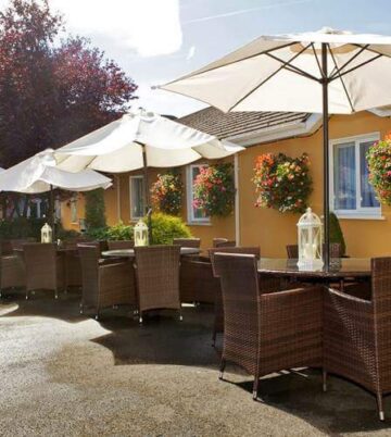 Charming outdoor seating at Hamlet Court Hotel with wicker furniture and floral decor.