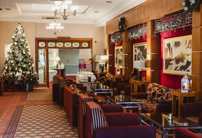 Elegant hotel lobby with festive decor and cosy seating area