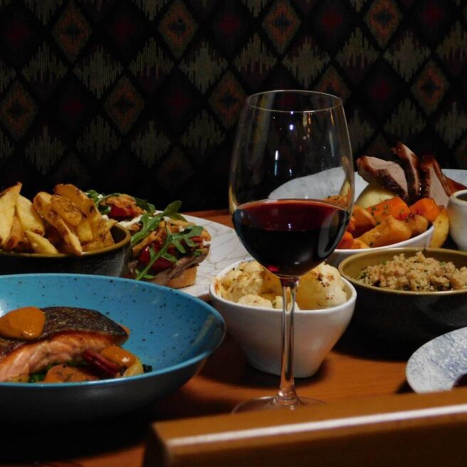 Elegant dining setup with gourmet dishes and wine at a hotel restaurant.