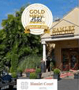 Entrance of Hamlet Court Hotel with lush greenery and welcoming atmosphere.