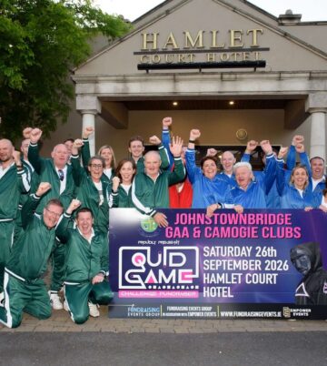 Group celebrating in front of Hamlet Court Hotel with event banner.