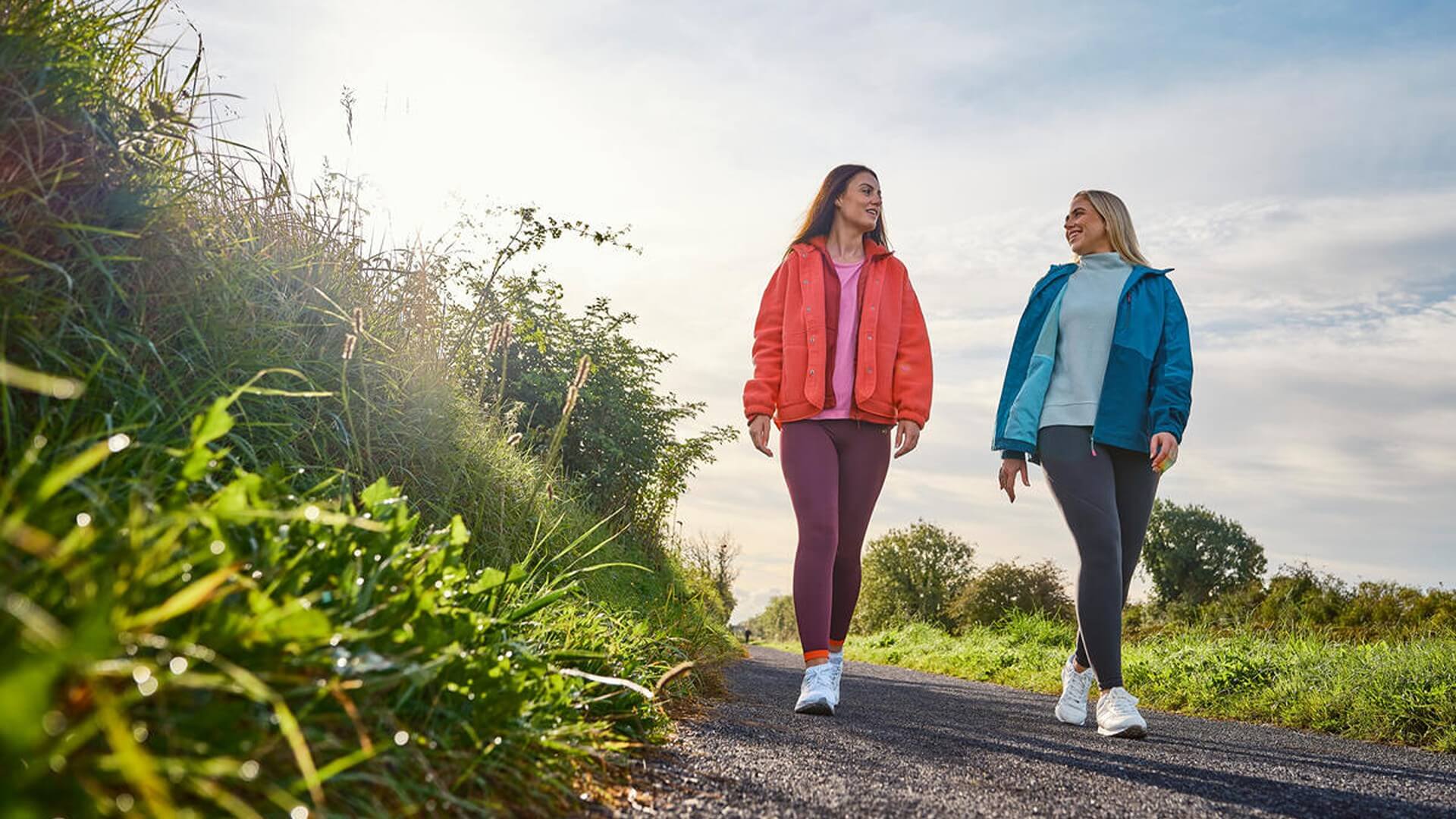 Two women walking on a scenic countryside path near Hamlet Court Hotel.