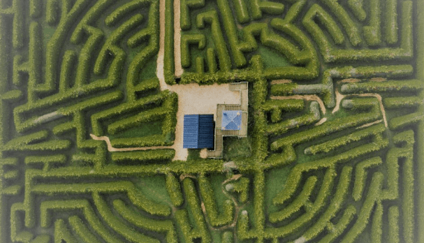 Aerial view of Hamlet Court Hotel's lush garden maze with a central seating area.